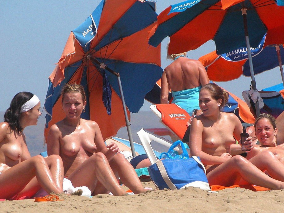 Amateurs girl topless group shot on the beach 