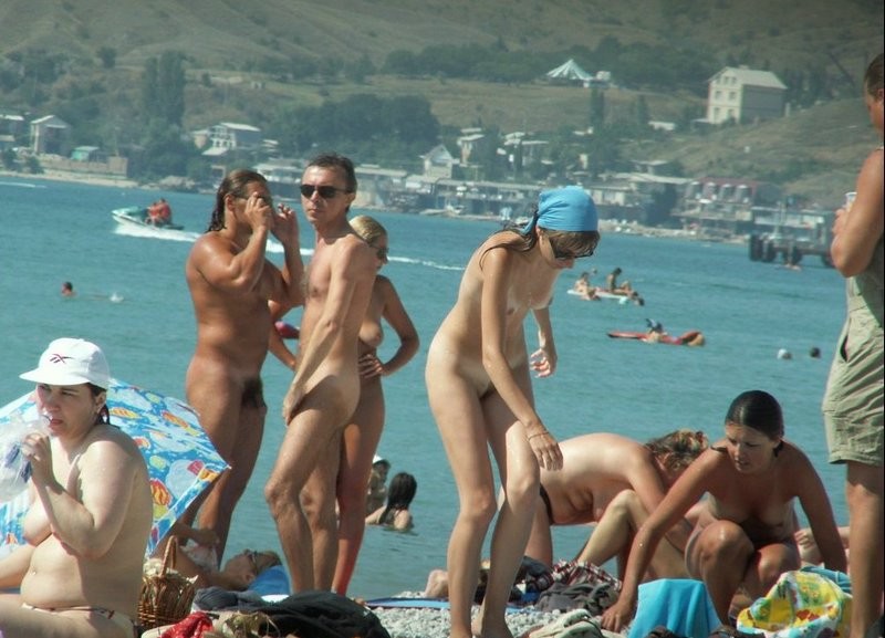 Couple of girls on busy nudist beach 