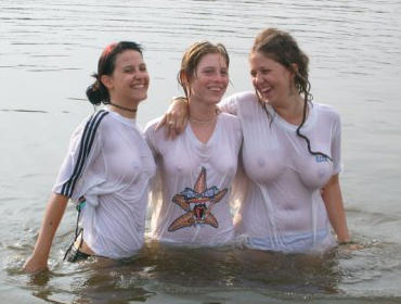 Funny girls on lake in wet shirts