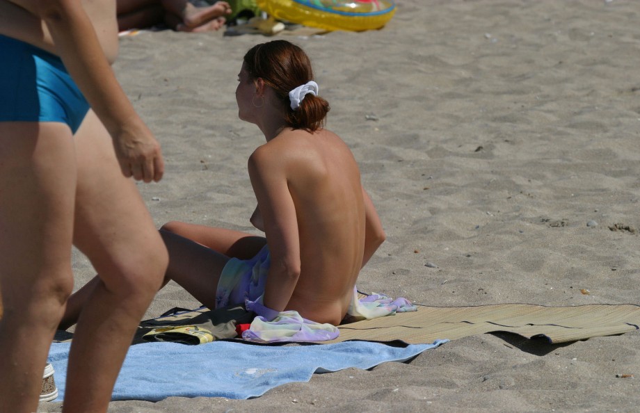 Topless teen getting changed on the beach