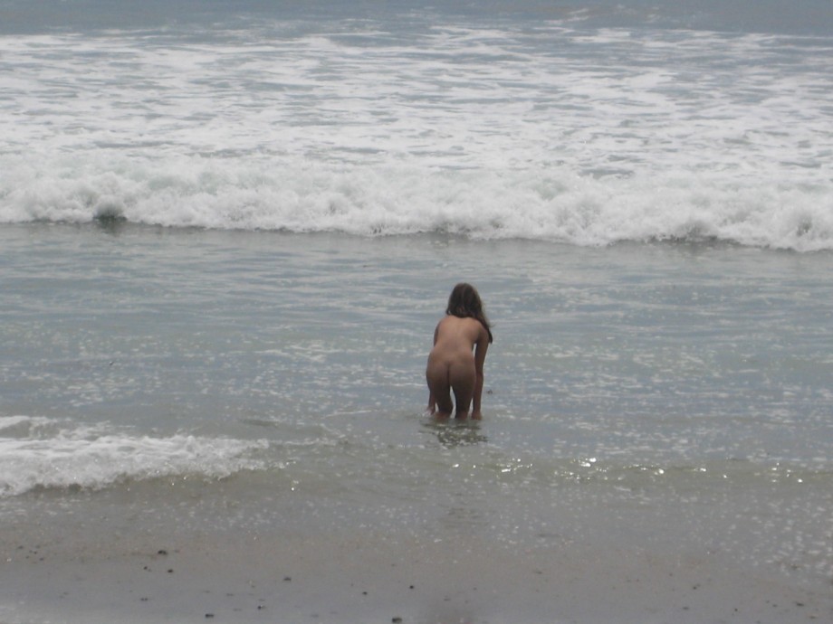 Brunette with pierced nipples on nudist beach