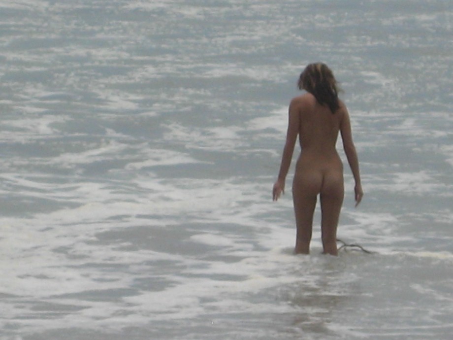 Brunette with pierced nipples on nudist beach